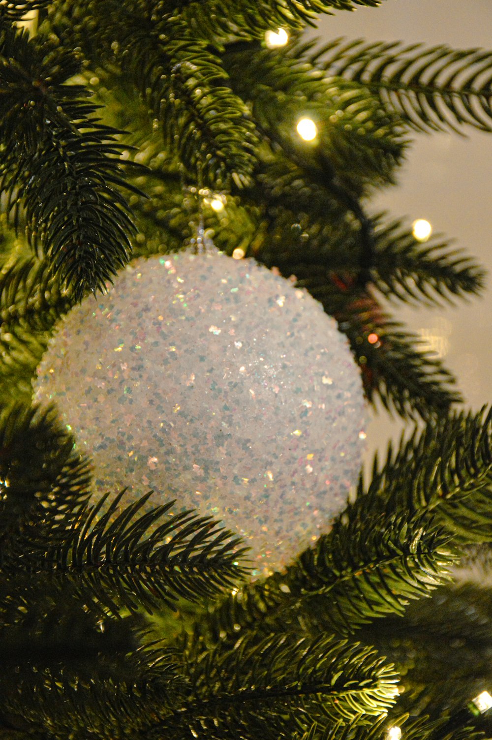 a white ornament hanging from a christmas tree