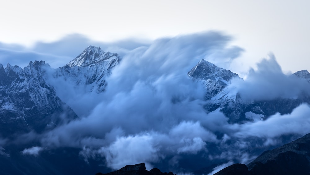 a mountain range covered in a cloud filled sky