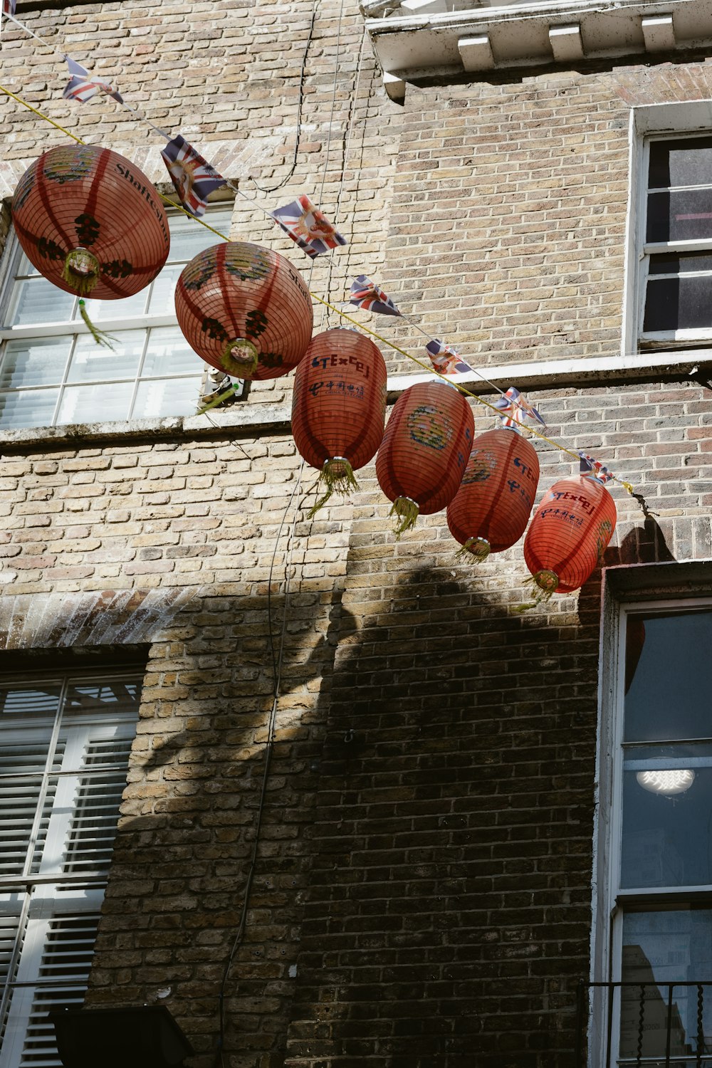 red lanterns hanging from the side of a brick building