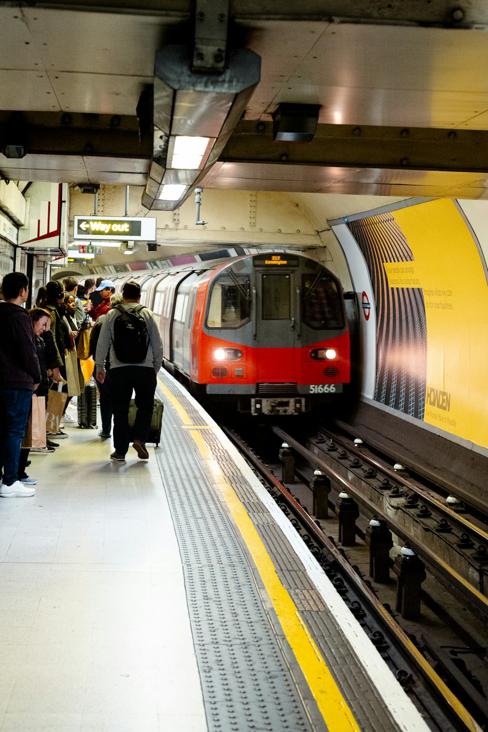 a group of people waiting for a train at a train station