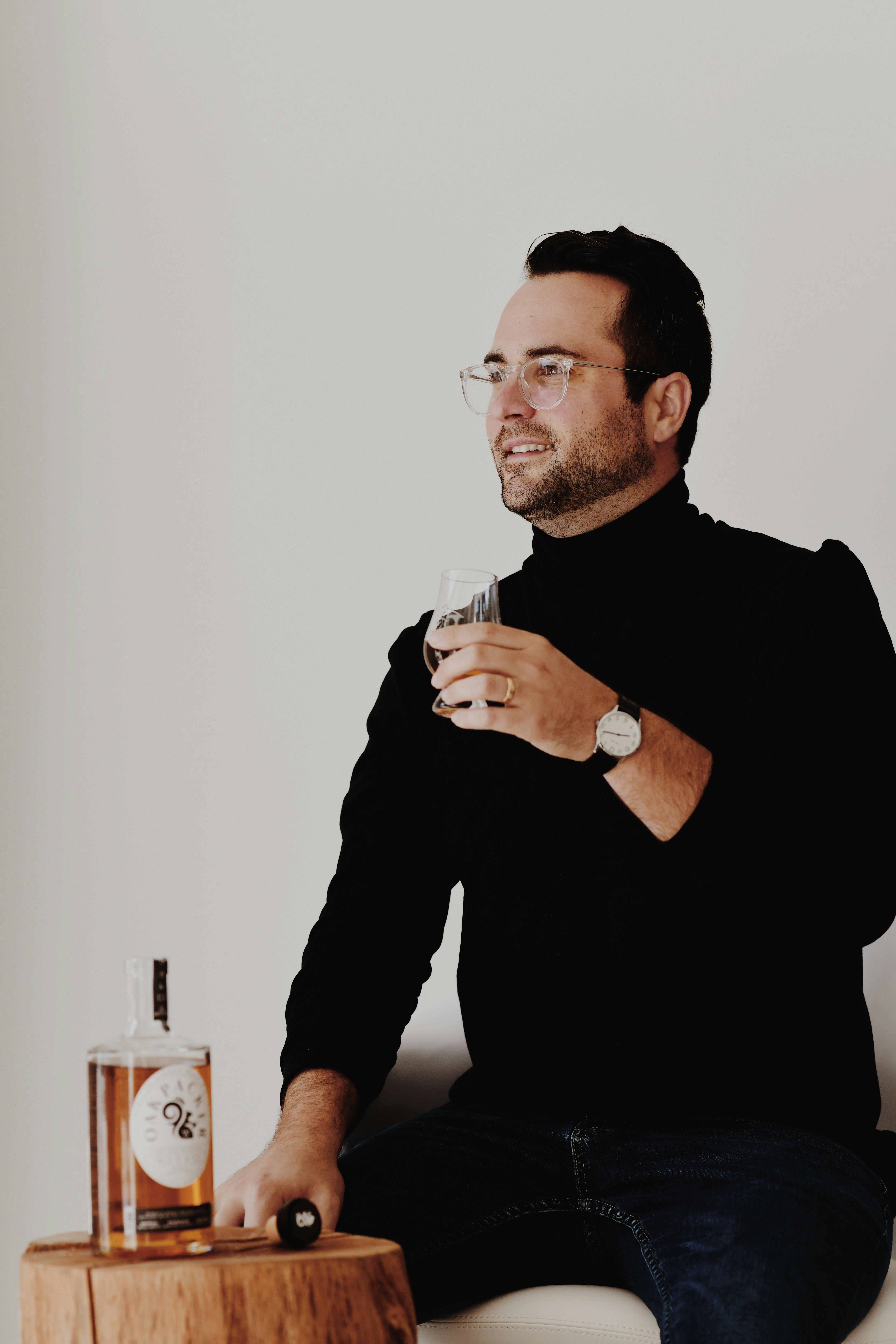 a man sitting on a couch holding a glass
