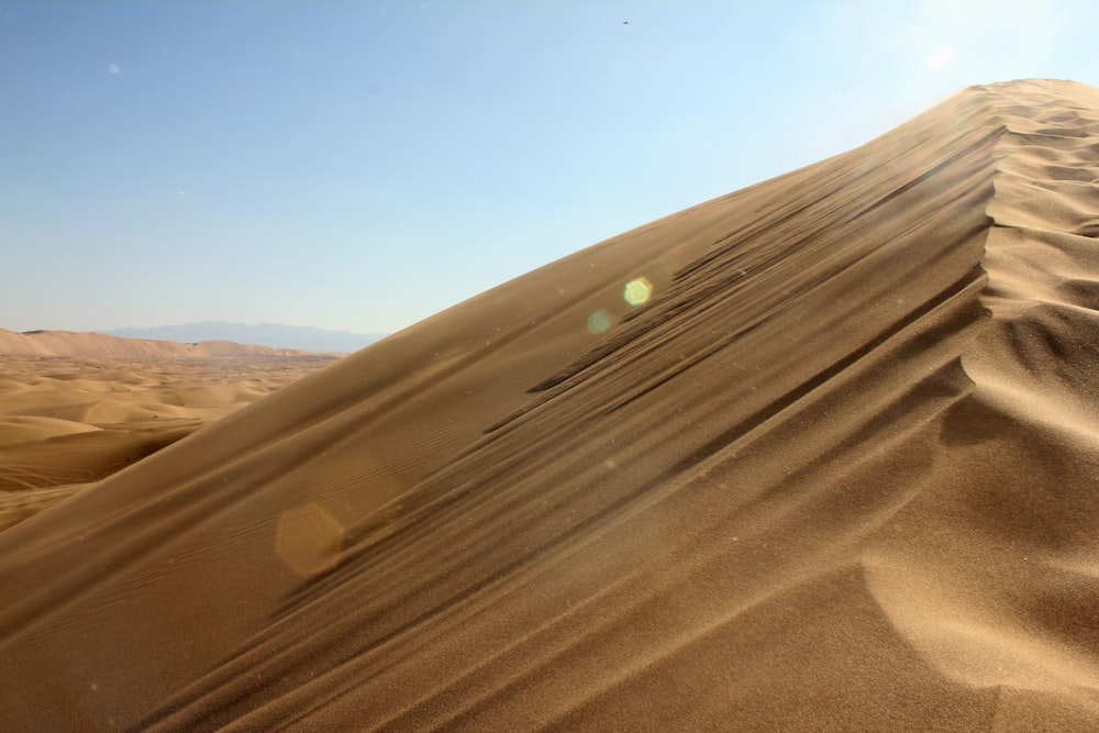 the sun shines on a sand dune in the desert