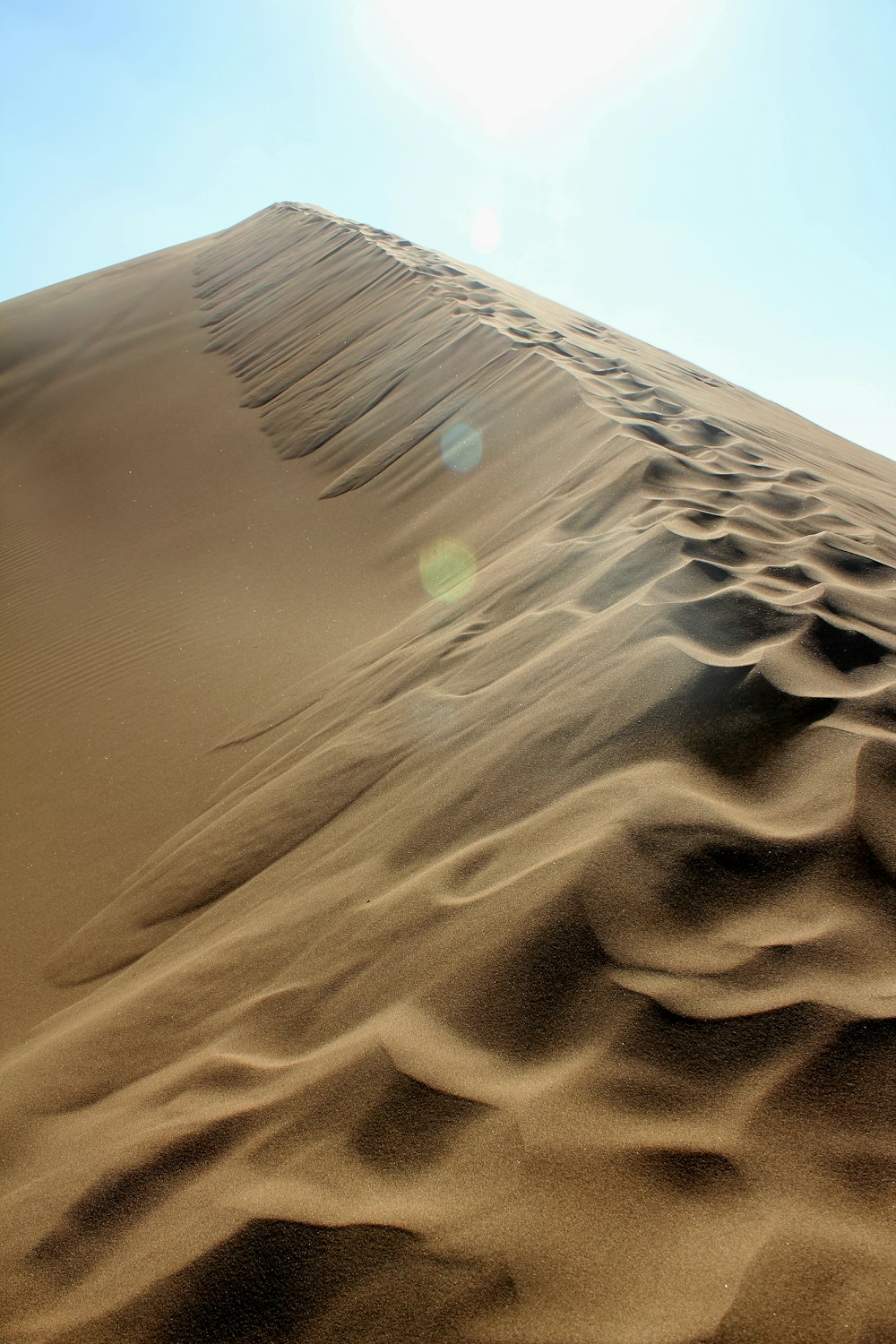 the sun is shining on a sand dune