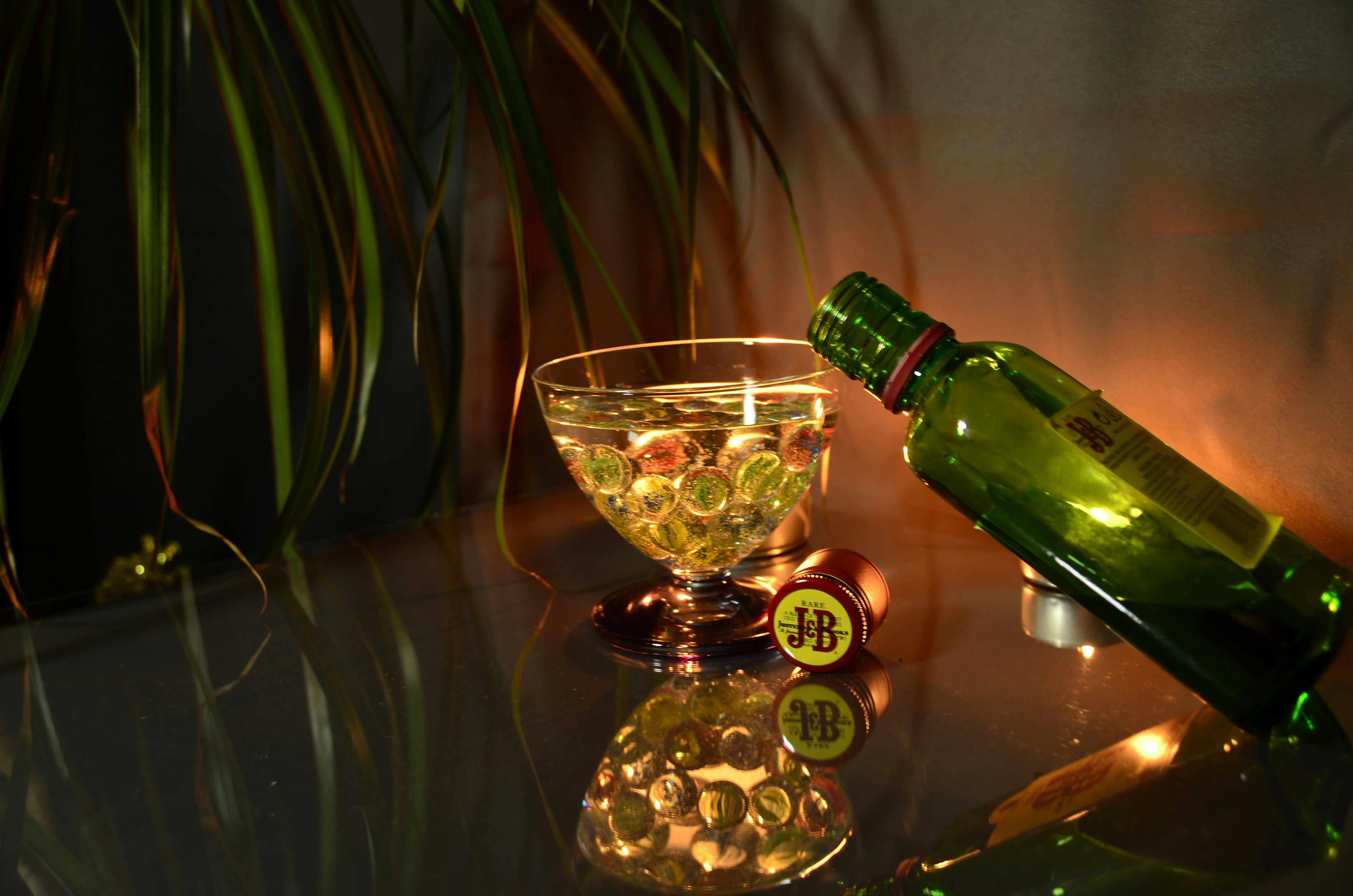 a bottle of beer next to a bowl of coins