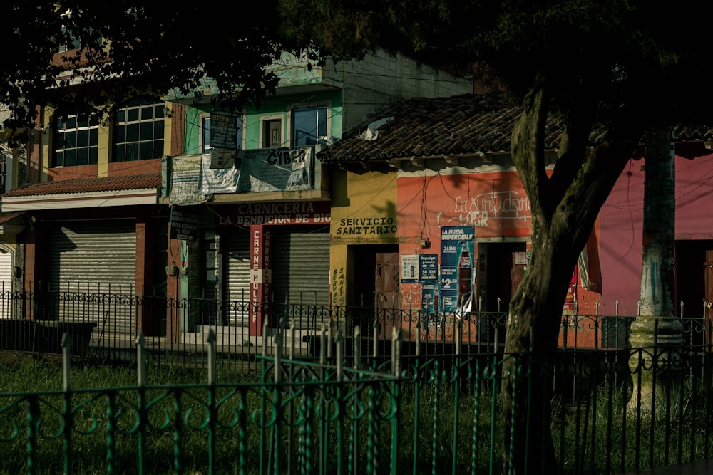 a row of buildings with a fence in front of them