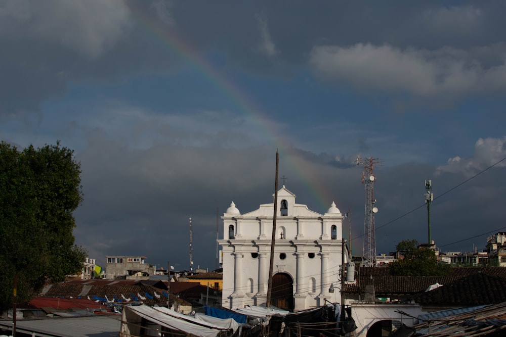a white church with a rainbow in the background