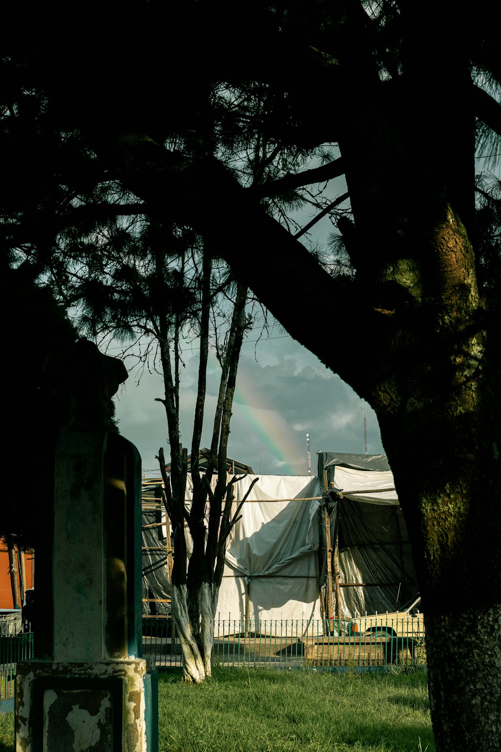 a tent is in the distance with a rainbow in the background