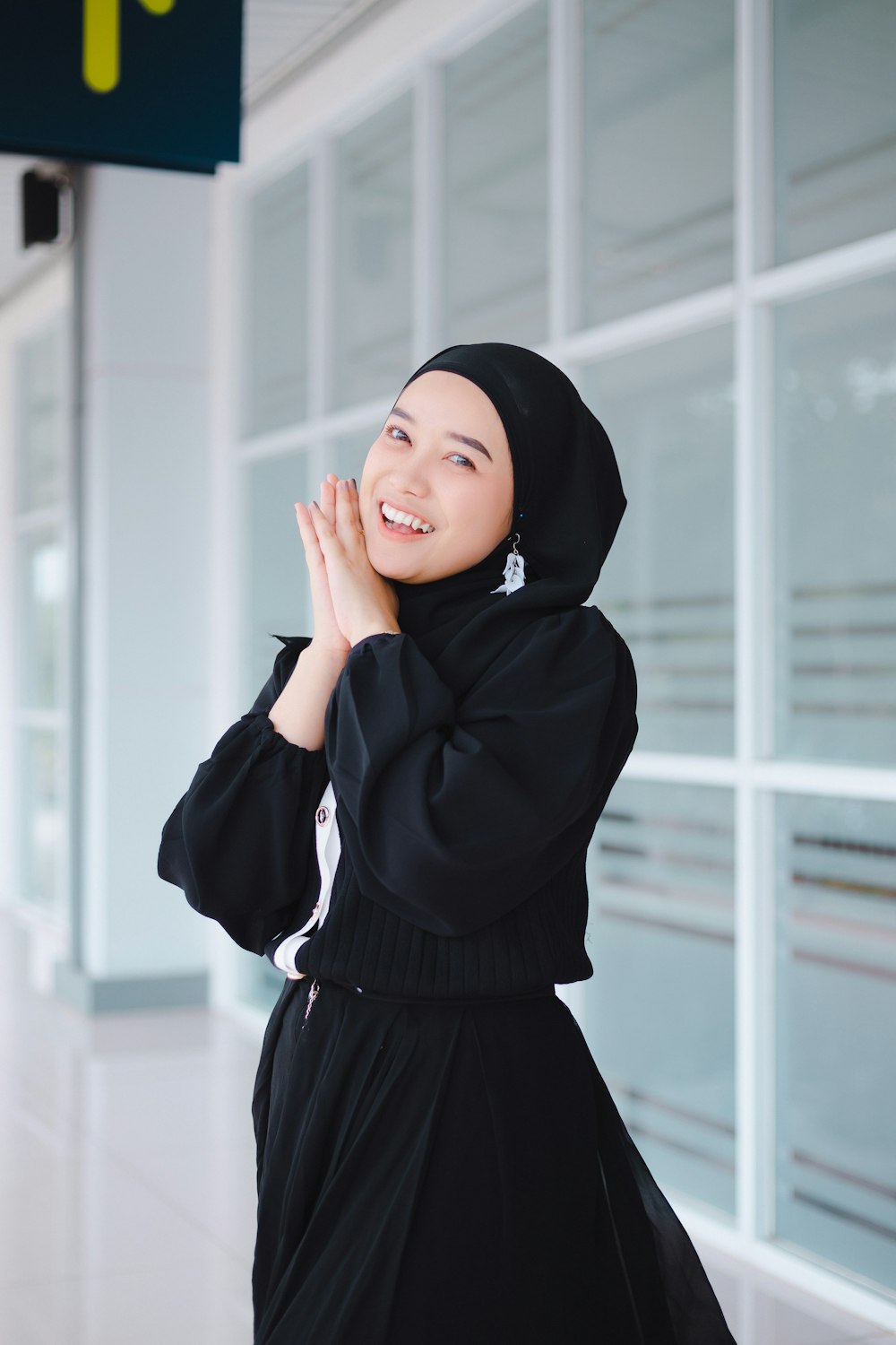 a woman in a black hijab standing in front of a building