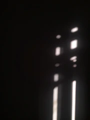 Soft light breaking through a dark grid, symbolizing insight and forward motion