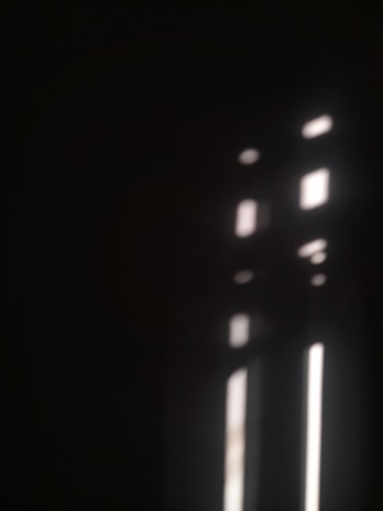 A vibrant yet understated mobile wallpaper with soft light flares on a dark background.