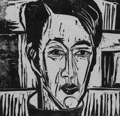 A black and white linocut portrait of a person with a solemn expression. The image features bold, angular lines and strong contrasts, emphasizing the facial features such as the eyes, nose, and lips. The background consists of abstract patterns and shapes, enhancing the starkness and intensity of the portrait.