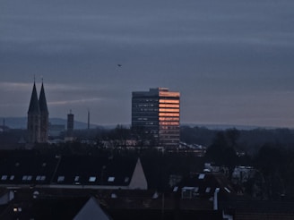 Colombian cityscape with a modern office building glowing during sunset.