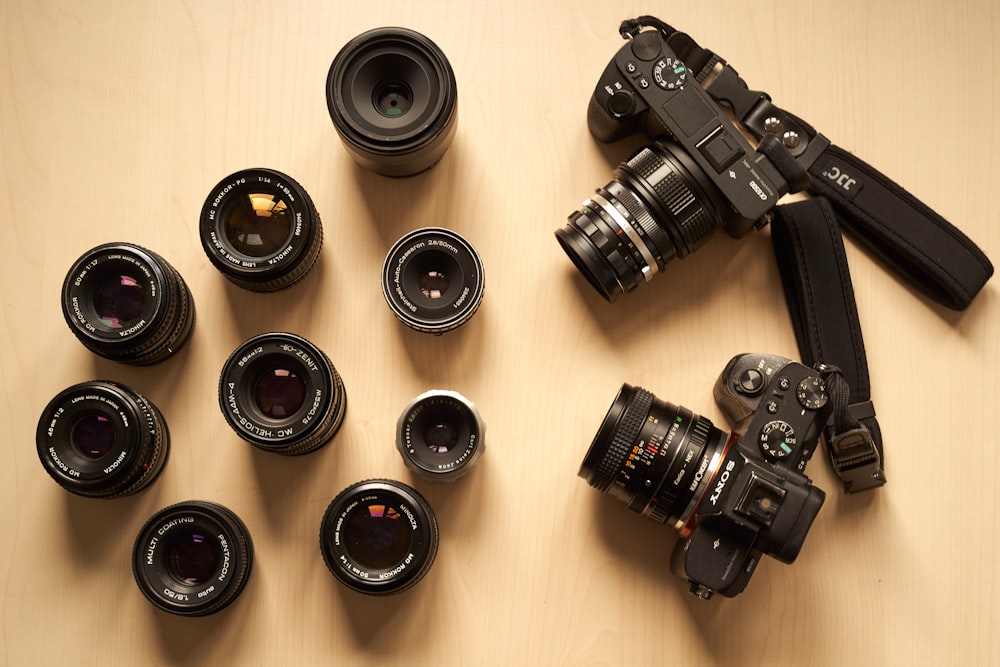 a group of cameras sitting on top of a wooden table