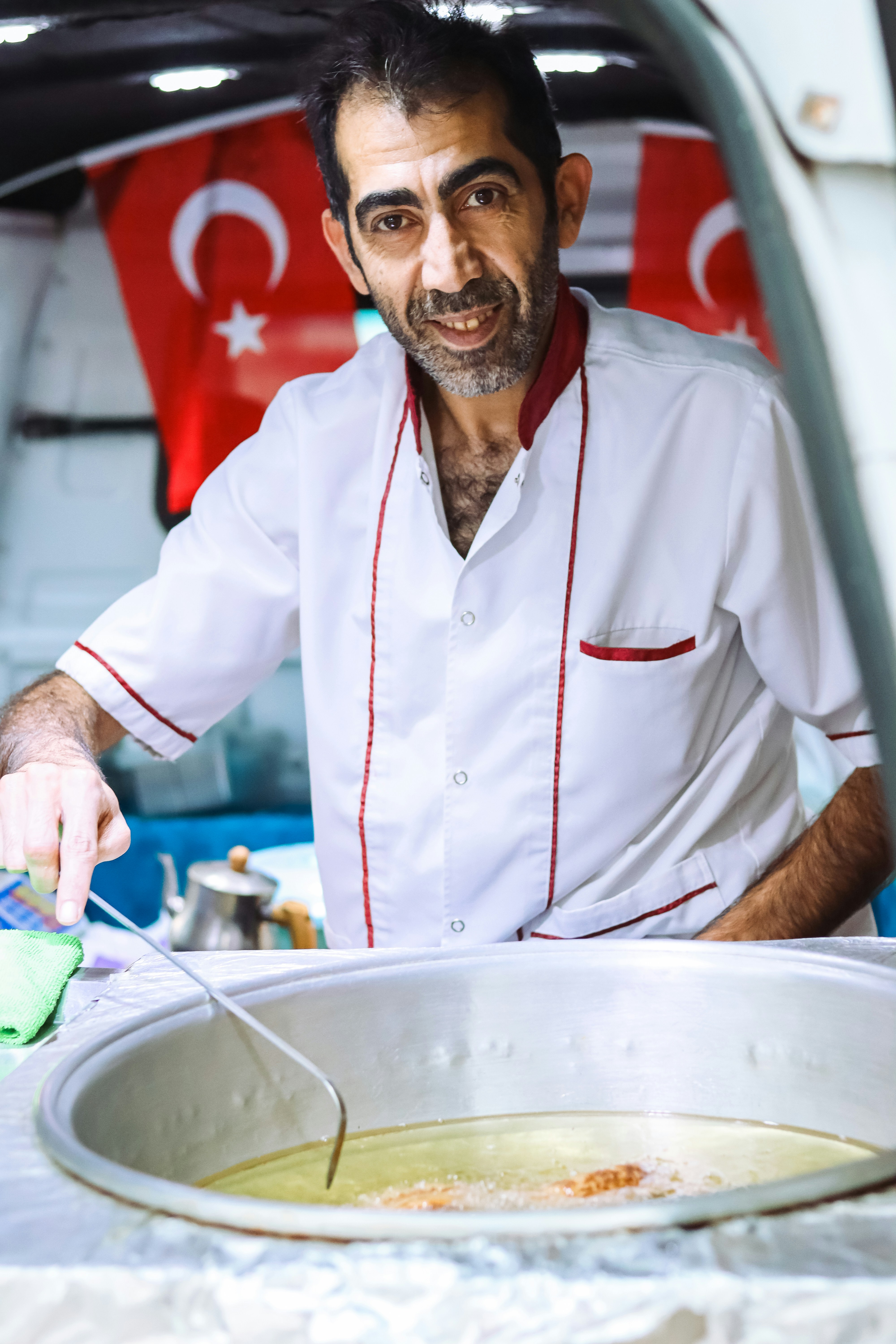 a man in a chef's uniform cuts into a bowl of soup