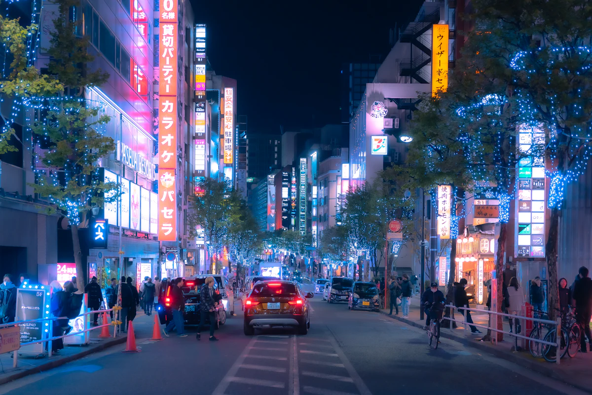 Busy Tokyo city street at night lit by colorful neon signs, capturing Asia's nightlife scene