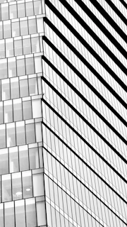 A detailed black and white architectural sketch of a modern urban building with clean lines and sharp angles.