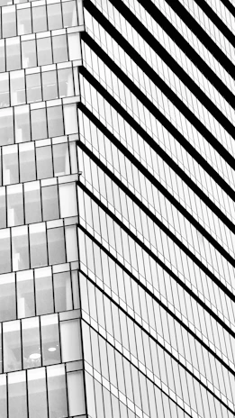 A detailed black and white architectural sketch of a modern urban building with clean lines and sharp angles.