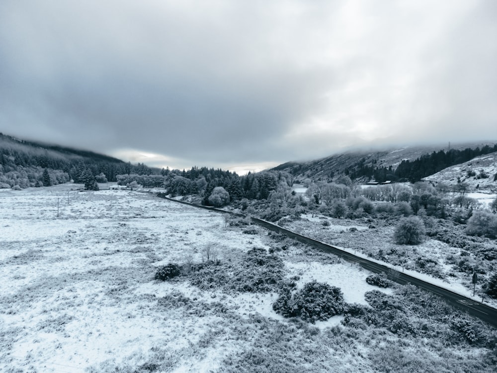 a snow covered field with a train on the tracks