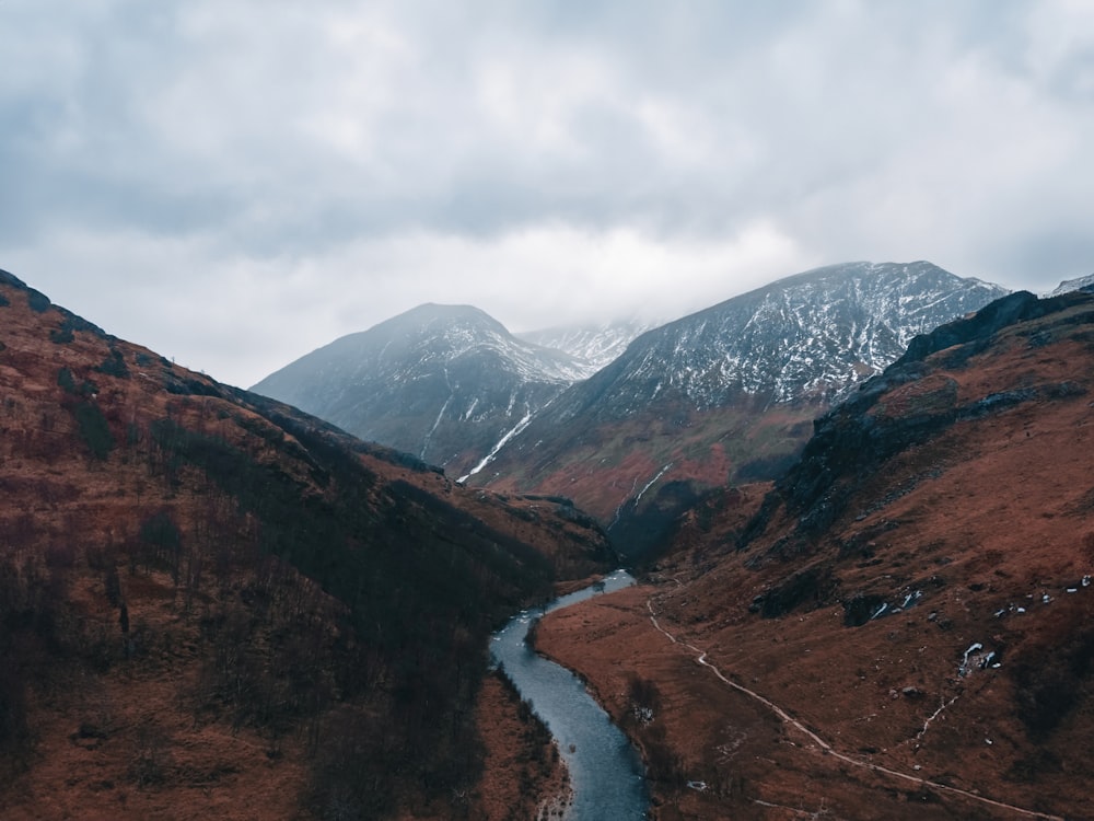 a river running through a valley surrounded by mountains