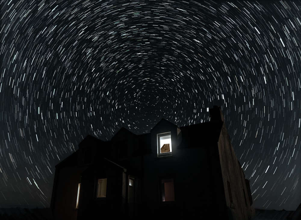 a star trail is seen in the sky above a building