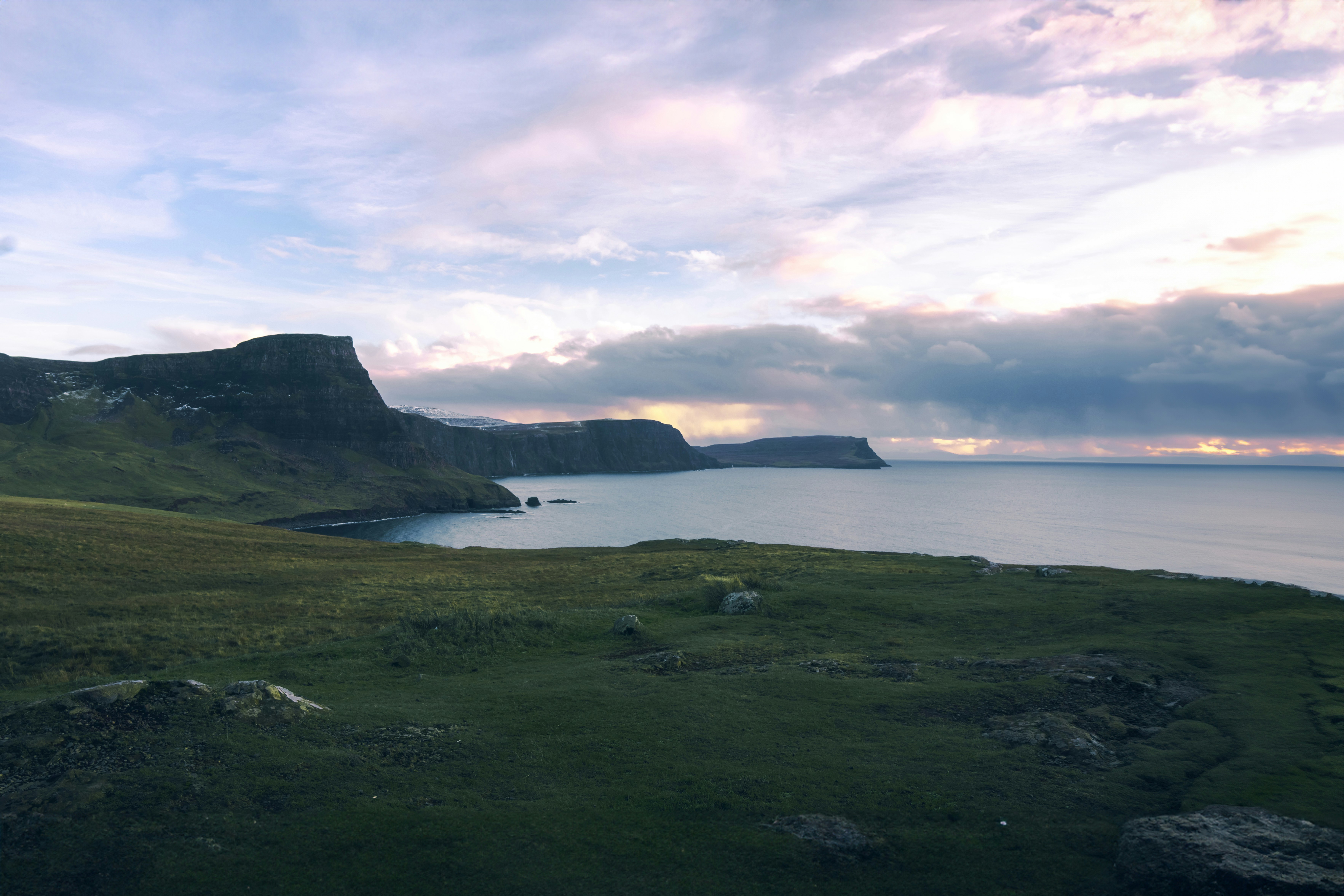 A large body of water surrounded by a lush green hillside photo Free