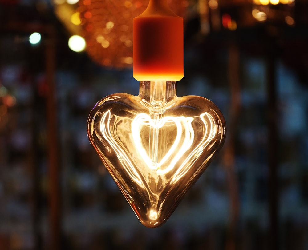 a heart shaped light bulb hanging from a ceiling