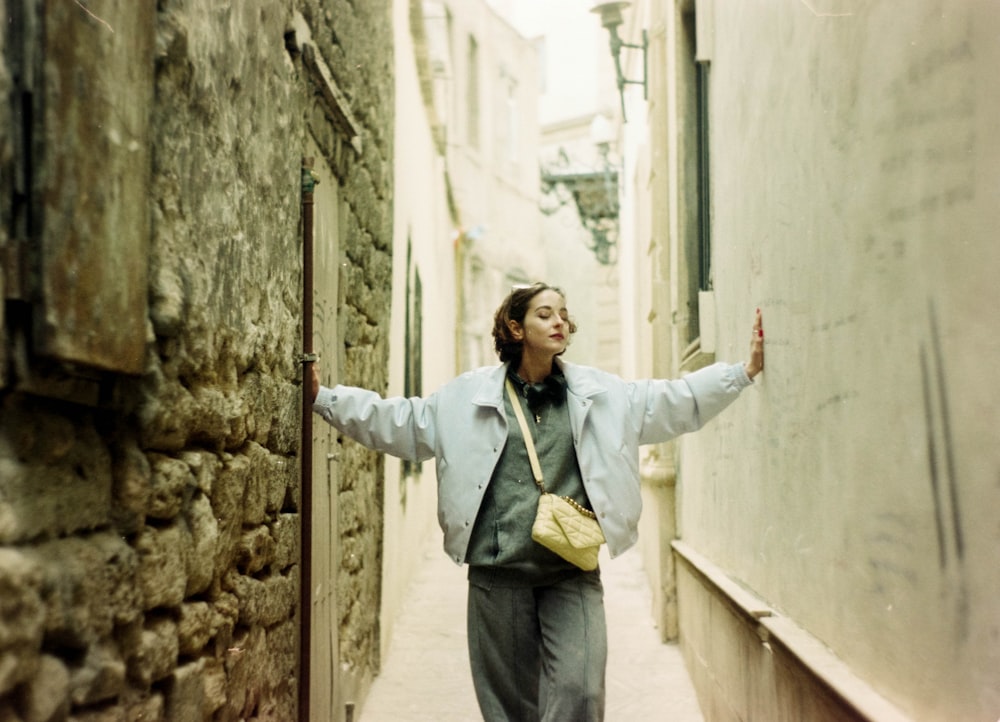 a woman walking down a narrow alley way