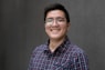 a man with glasses smiling for the camera
