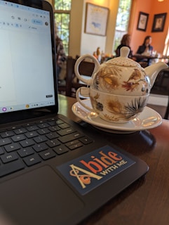 A warm, inviting workspace with a laptop, notebooks, and a cup of tea, symbolizing focused teen and parent coaching.