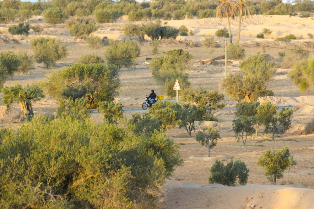 a man riding a motorcycle down a dirt road