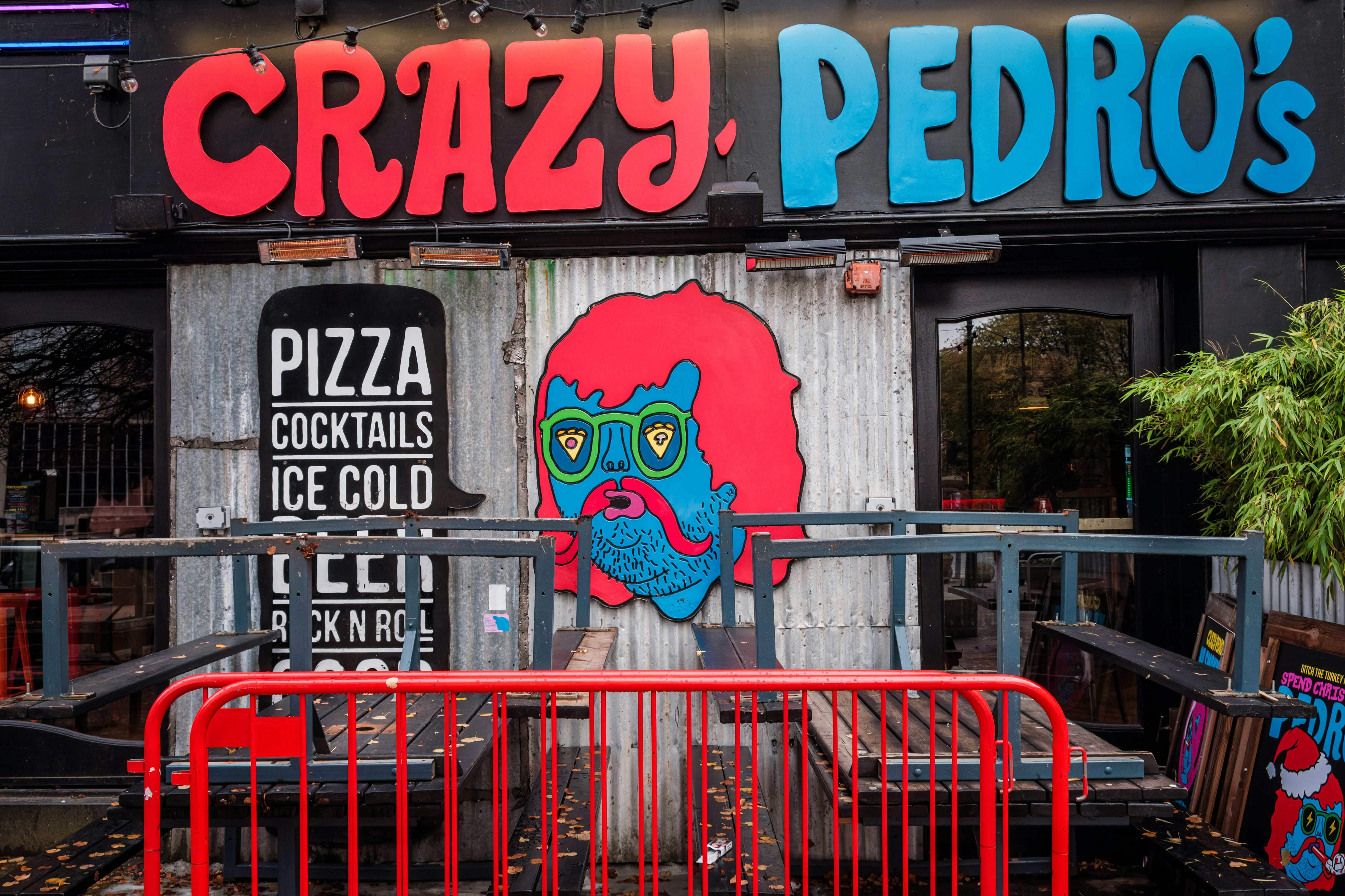 a restaurant with a red gate and a sign that says crazy pedro