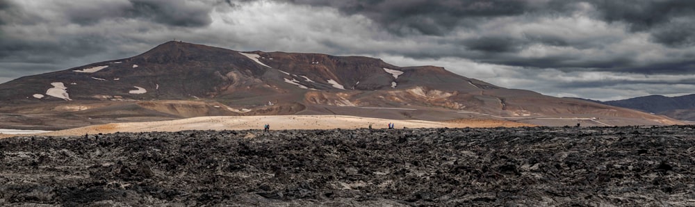 a group of people standing on top of a mountain under a cloudy sky