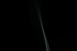 Elegant dark-themed contact form with golden accents and a subtle cigar smoke background.