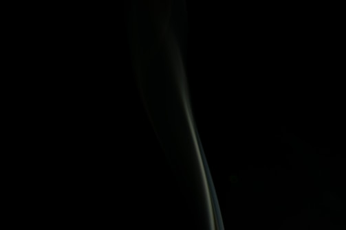 Elegant dark-themed contact form with golden accents and a subtle cigar smoke background.