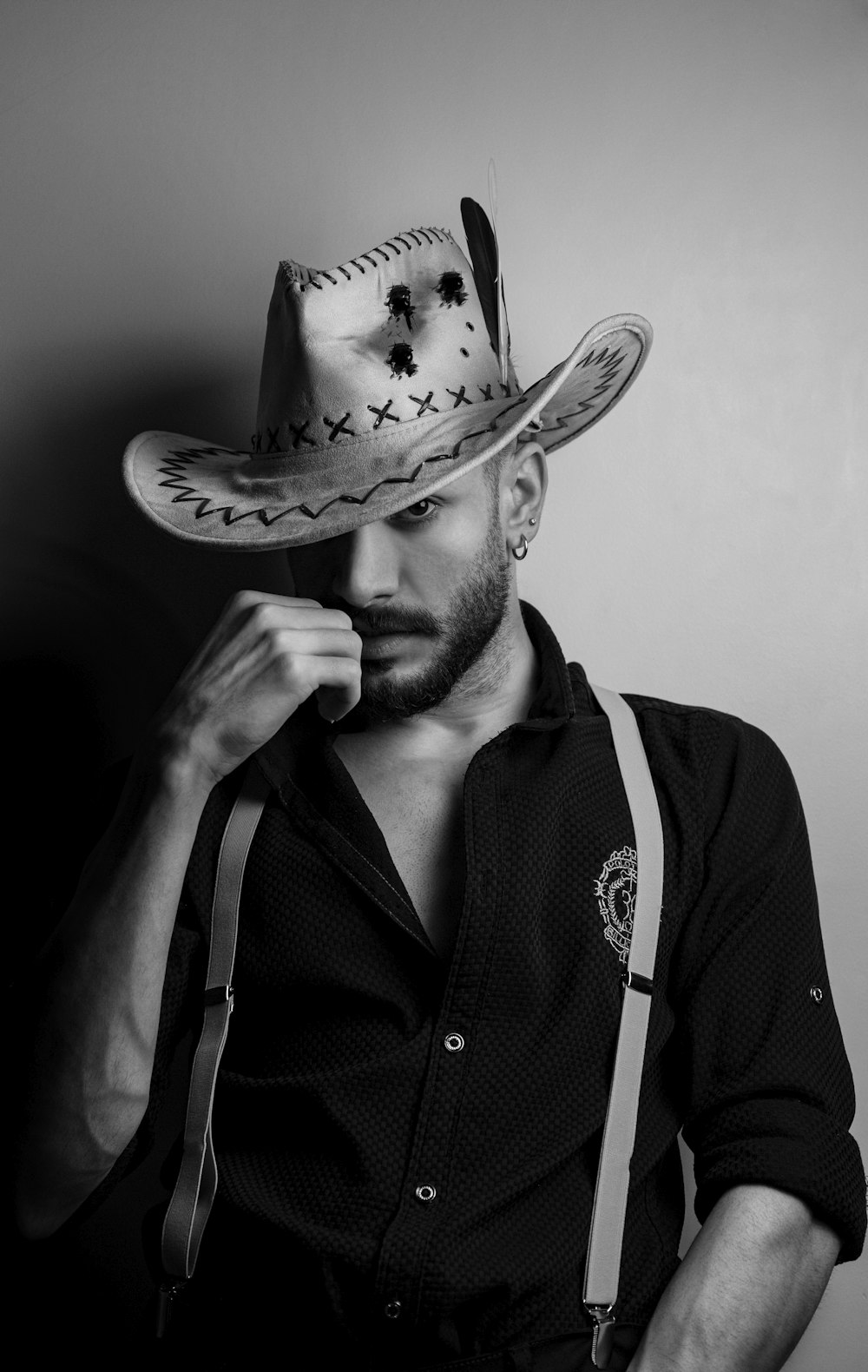 a man wearing a cowboy hat and suspenders