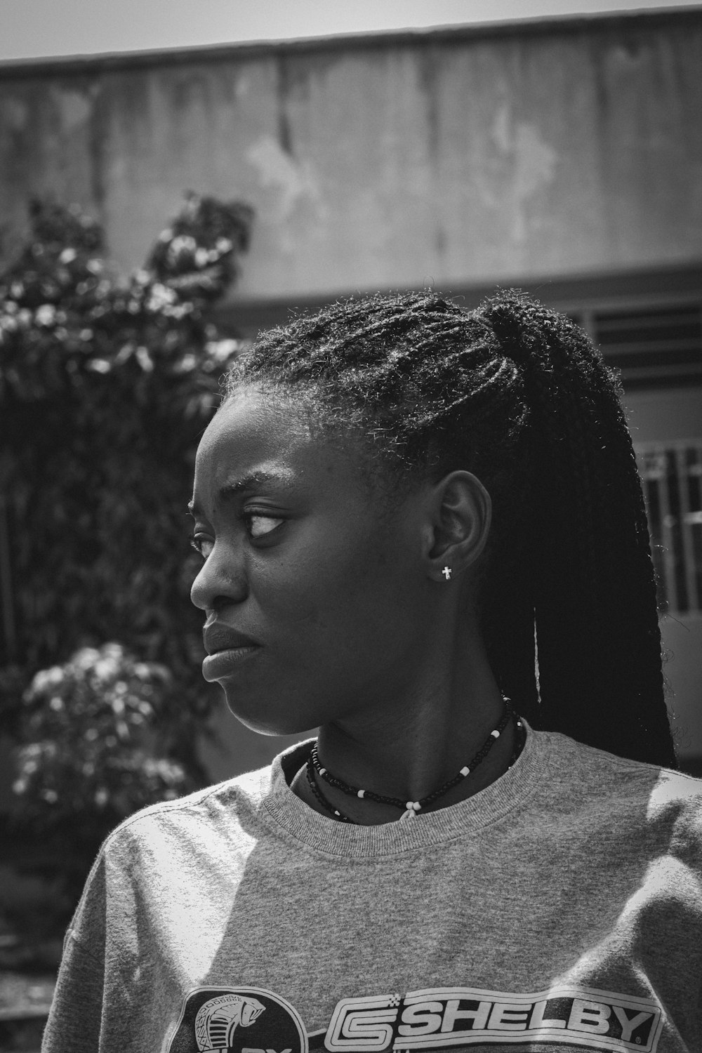 a black and white photo of a woman with braids