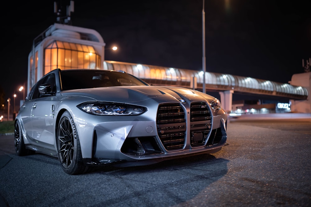 a silver sports car parked in front of a building