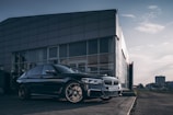 A sleek, modern car parked in an urban setting with a city skyline in the background.