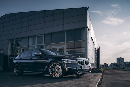 A sleek, modern car parked in an urban setting with a city skyline in the background.