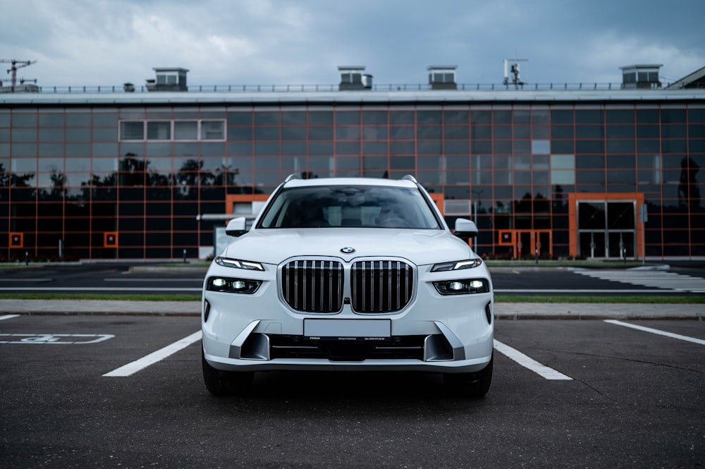 a white bmw suv parked in a parking lot