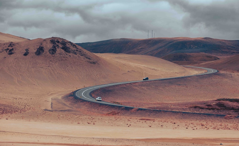 a car driving down a winding road in the desert