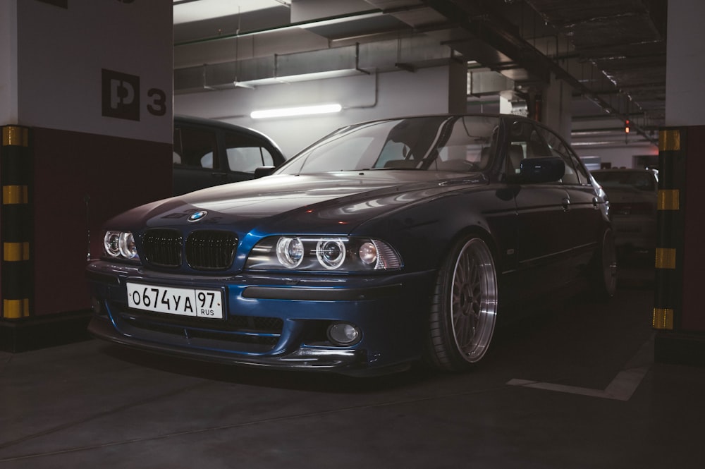 a car parked in a parking garage next to another car