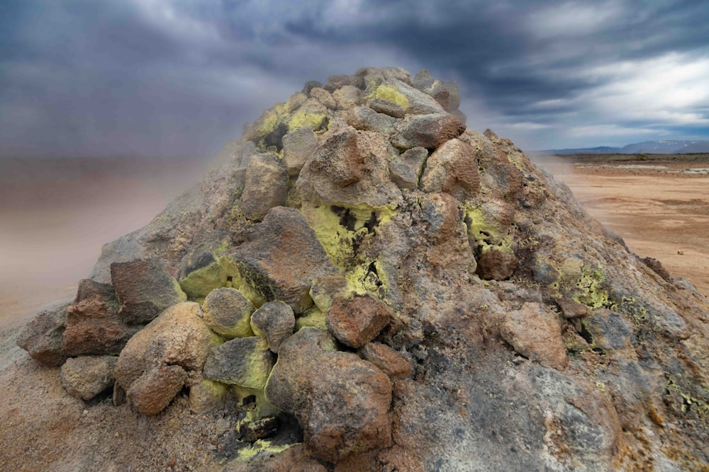 a large pile of rocks sitting on top of a dirt field