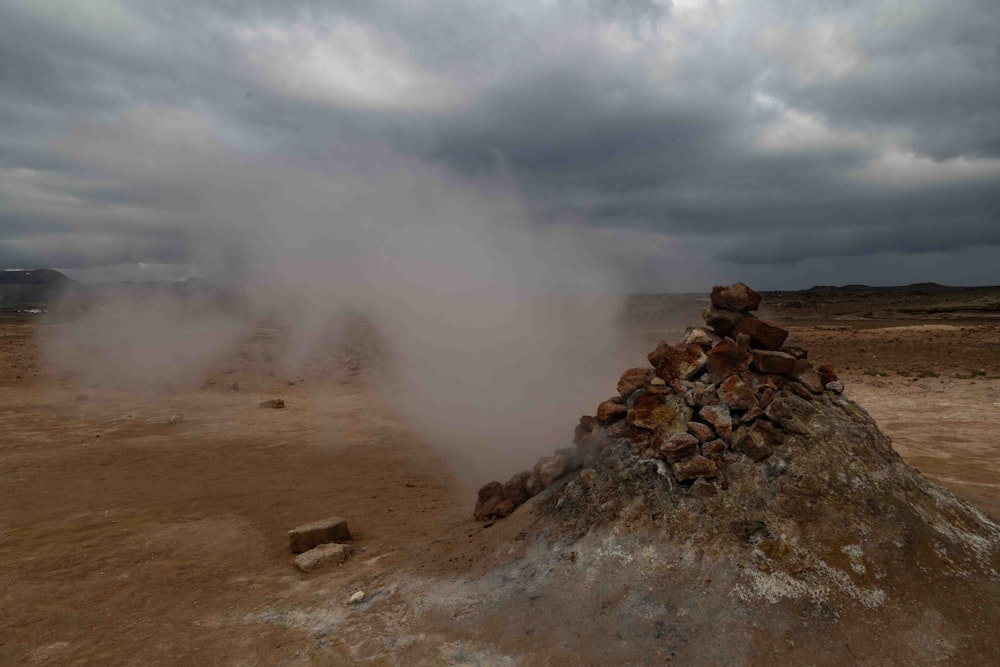 a large pile of rocks sitting on top of a dirt field