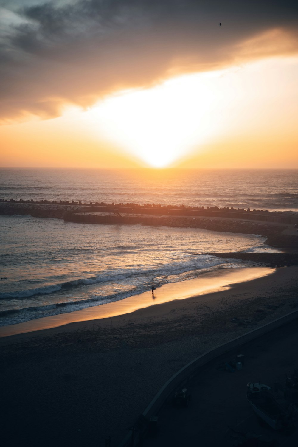 the sun is setting over the ocean on the beach