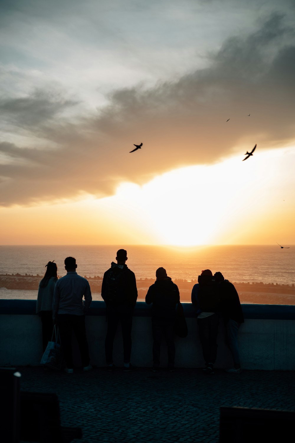 a group of people standing next to each other near the ocean