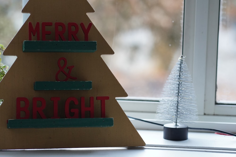 a wooden christmas tree sitting on top of a window sill