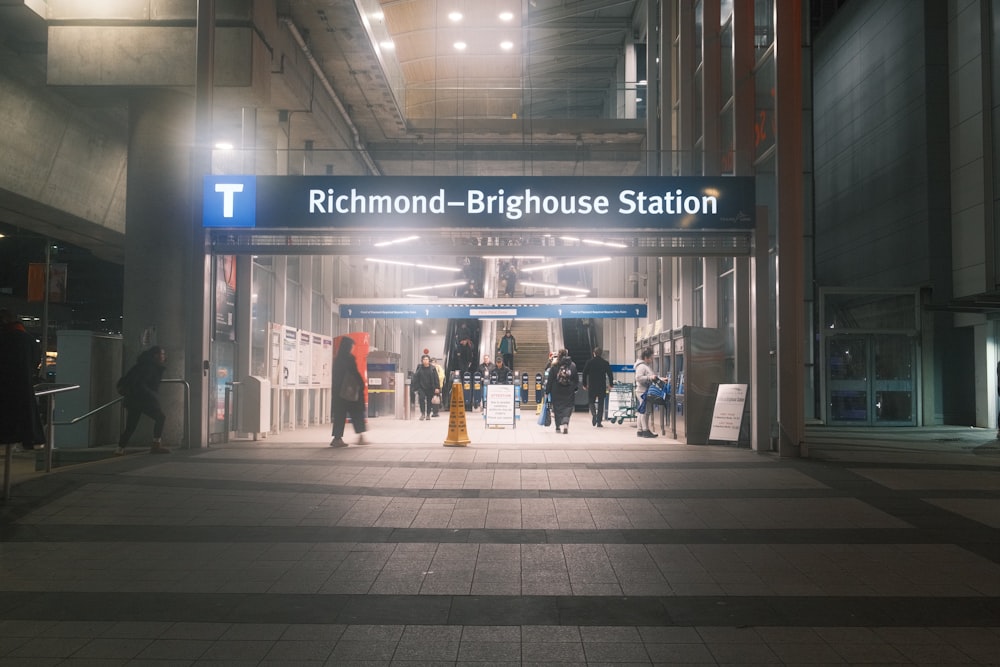 a train station with people walking in and out of it