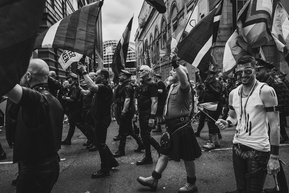 Eine Gruppe von Menschen, die eine Straße entlang gehen und Fahnen halten