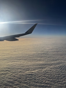 3D-rendered airplane soaring above cotton-candy clouds with soft shadows.